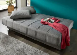 Frei im Raum aufstellbares Schlafsofa mit Dekokissen und Bettkasten
